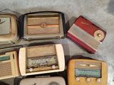 many old radio ' s sitting on the floor next to each other