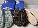 three pairs of shoes are lined up on a counter top