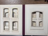 two open books on a table with a clock in the background