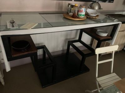 une petite cuisine avec un plan de travail en verre et des tabourets