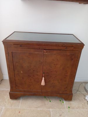 une armoire en bois avec un plateau en verre, posée sur un sol carrelé