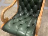 fauteuil en cuir vert avec une structure et des accoudoirs en bois, dans un magasin