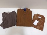 Trois pulls pour homme, dont un marron et un autre marron, sont posés sur une table blanche