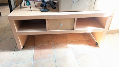 un meuble TV sur lequel sont posées plein de chaussures