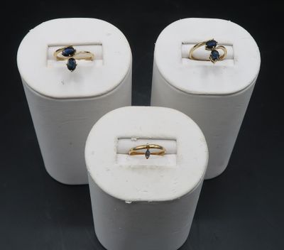 three rings are sitting in a white box on a black surface