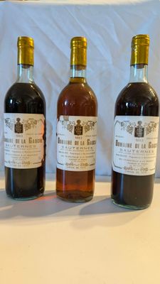 trois bouteilles de vin posées sur une table, l'une à côté de l'autre