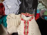 une valise remplie de vêtements, avec un ours en peluche à l'intérieur