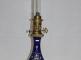un petit vase bleu sur lequel est posée une bougie
