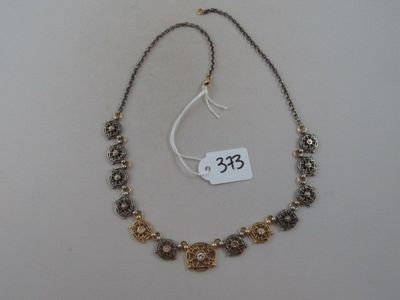 gros plan d'un collier sur une surface blanche avec une étiquette de prix