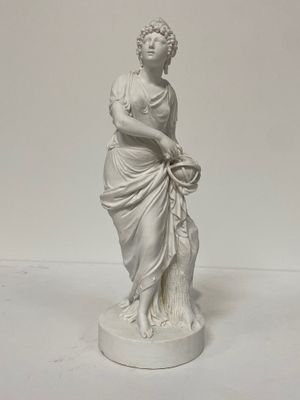 une statue représentant une femme tenant un panier de fleurs