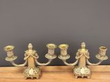 two silver candlesticks on a wooden table with a gray background