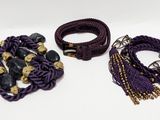 purple and gold bracelets and bracelets with tassels on a white surface