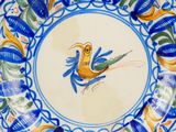 a blue and yellow plate with a bird on it