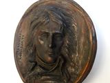 a bronze plaque of a woman with long hair