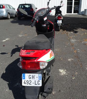 motorcycles parked in a parking lot next to a white building