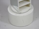 a small white cabinet with a mirror on top of it