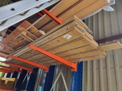 plusieurs pièces de bois sont empilées dans un entrepôt