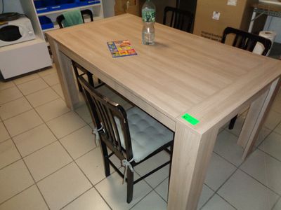 une table en bois avec des chaises et une bouteille d'eau posée dessus