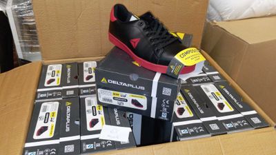 une boîte contenant une paire de chaussures noires et rouges
