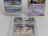 trois cartes Pokémon dans des pochettes en plastique posées sur une surface blanche