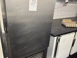 a small refrigerator in a kitchen with a microwave on top