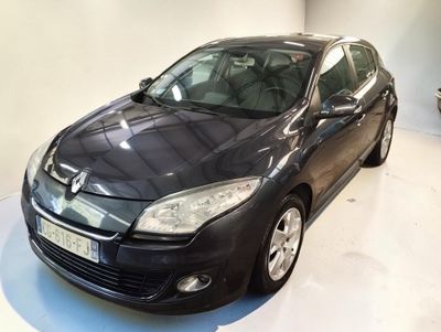 La voiture noire est garée sur le sol blanc de la pièce.