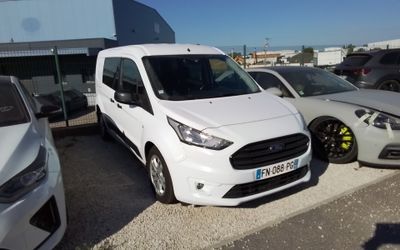 une camionnette blanche garée dans un parking à côté d'autres voitures