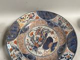 une assiette bleue et orange posée sur une table à côté d'une tasse et d'une soucoupe