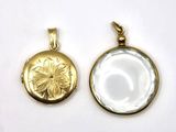 a close up of two gold pendants on a white surface