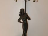a statue of a woman holding a bouquet of flowers on a table