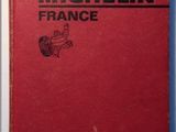 an old red book sitting on top of a white table