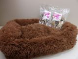 a dog bed that is on a table with a bag of treats