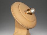 sculpture of a hat with a pearl on top of it
