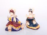 pair of ceramic figurines of a woman and a man sitting on a bench