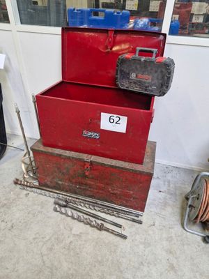 une pile de boîtes rouges sur lesquelles sont posés des outils