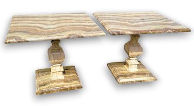 pair of marble tables on pedestals on a white background