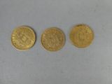three gold coins sitting on top of each other on a table