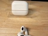 a pair of airpods sitting on a table next to a clear box