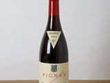 la bouteille de vin rouge est posée sur une table en bois