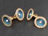 deux paires de boutons de manchette bleus et dorés sur un fond noir