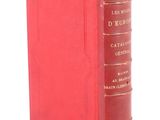 a red book sitting on top of a table next to a white wall