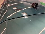 a close up of a shiny car with a flower on it ' s hood