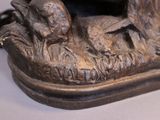 a bronze statue of a duck and a duckling on the ground