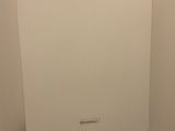 une photo d'une salle de bains avec des toilettes et un distributeur de papier accroché au mur