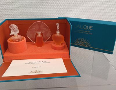 une vitrine en verre contenant deux flacons de parfum