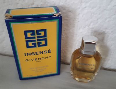 an image of a bottle of perfume sitting next to a box