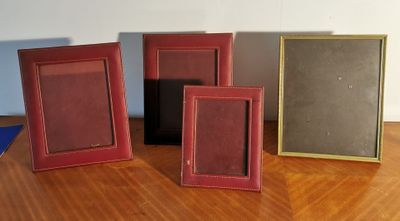 three different colored frames are sitting on a wooden floor