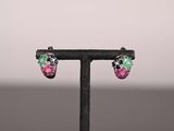 a pair of multicolored earrings on a black stand