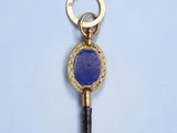 une clé en or sertie d'une pierre bleue