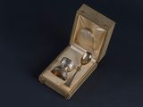 a silver spoon and spoon in a box on a black surface